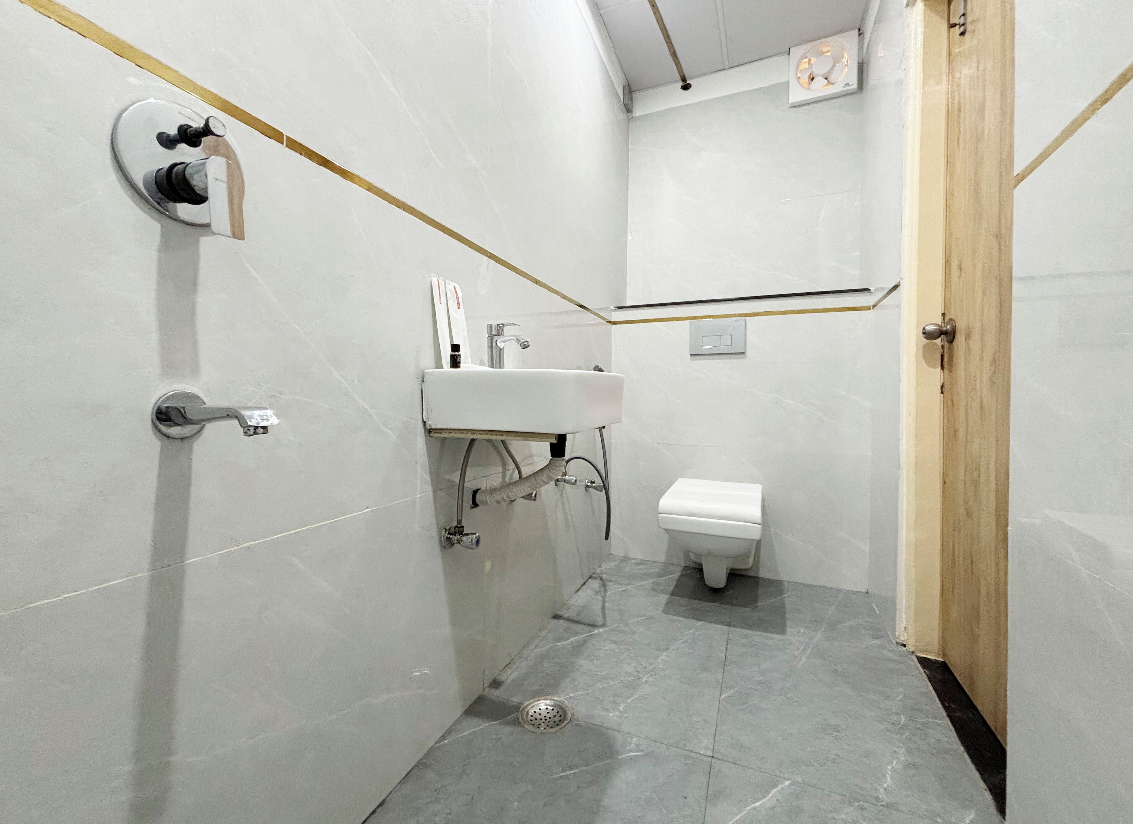 A small, clean bathroom with a toilet, sink, and shower.