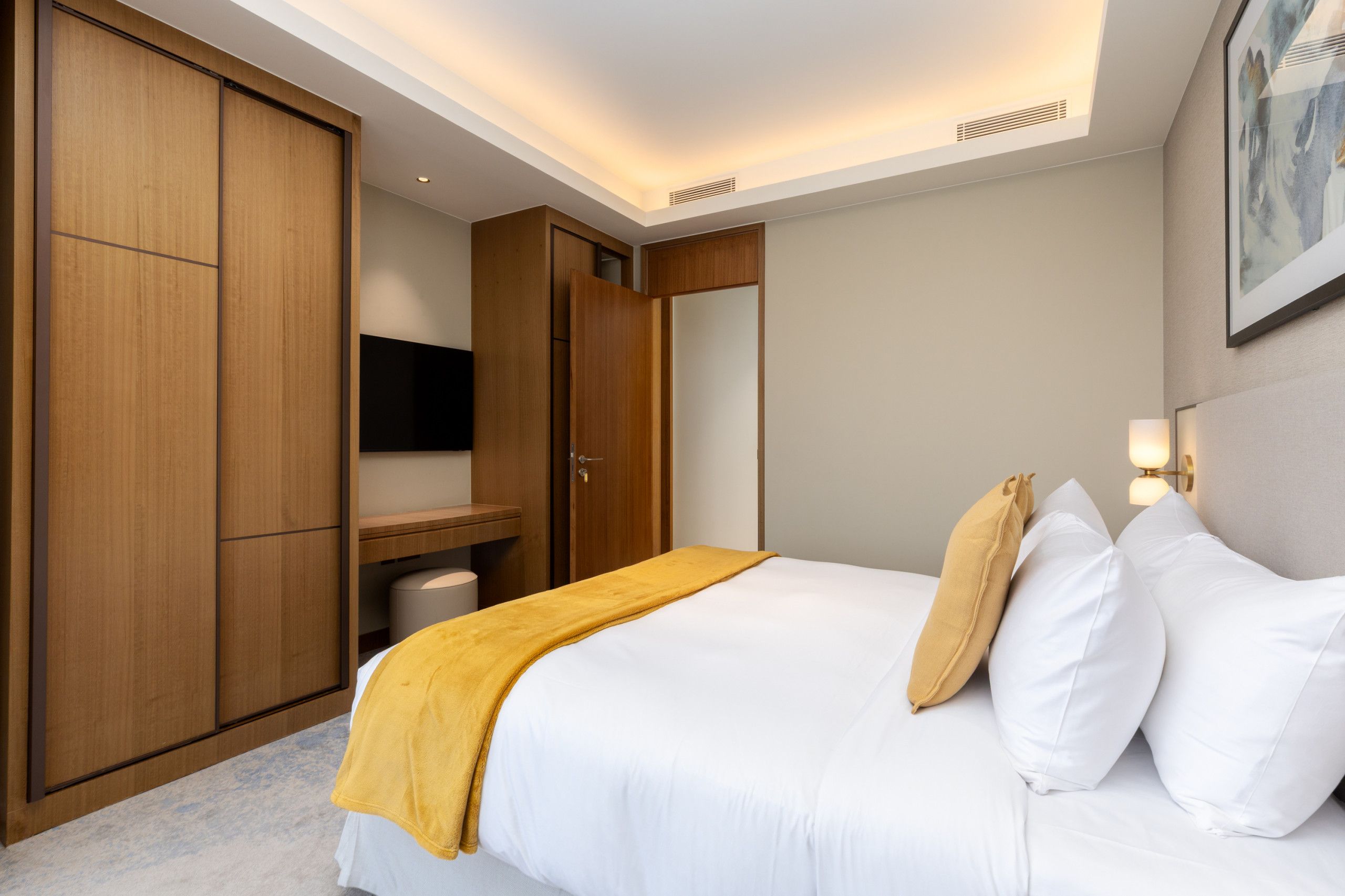 Une chambre d’hôtel comprenant un lit, une armoire, un bureau et un téléviseur.
