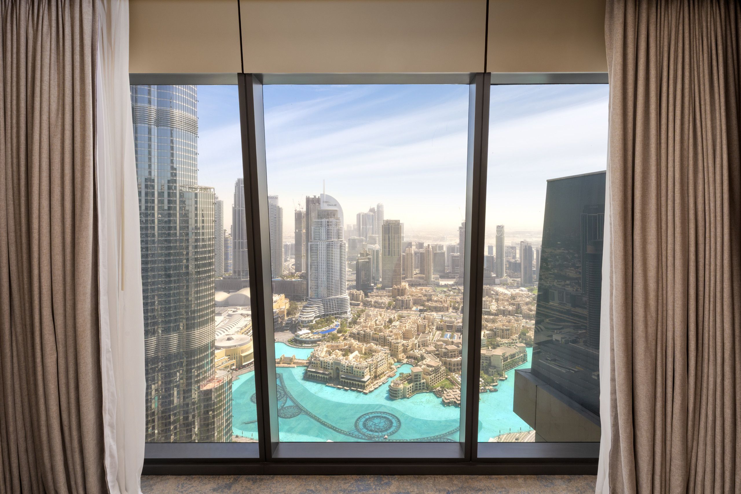 Habitación de hotel de gran altura con una vista panorámica de la ciudad y un puerto deportivo.