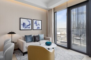 Ein modernes Hotelzimmer mit einer Couch, einem Couchtisch und einem Balkon mit Blick auf die Stadt.