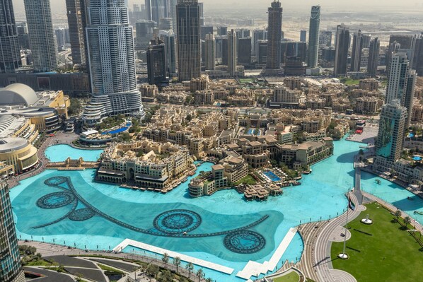 A high-rise hotel with a central courtyard, multiple swimming pools, and surrounding high-rise buildings.