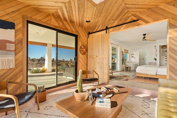 A modern interior with wooden paneling, a cactus on a table, and a view of the desert outside.