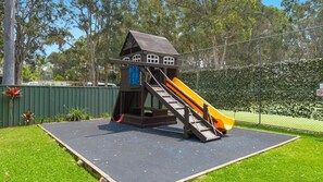 A playground with a slide and climbing structure.