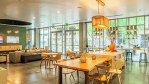 A spacious, well-lit interior with a modern dining area, comfortable seating, and large windows offering natural light and views. - Luxury Stay at DT PHX|Balcony,Pool,Gym,Parking,W/D (Phoenix)