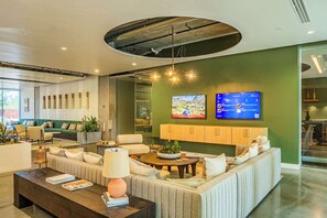 A modern living room with a sofa, coffee table, and TV mounted on the wall.