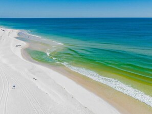 A beach with clear blue water and white sand.