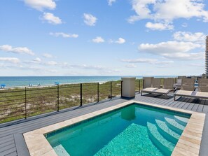 A rooftop pool with a view of the beach and ocean.