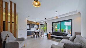 Un salon moderne avec un canapé, un fauteuil et un coin repas.