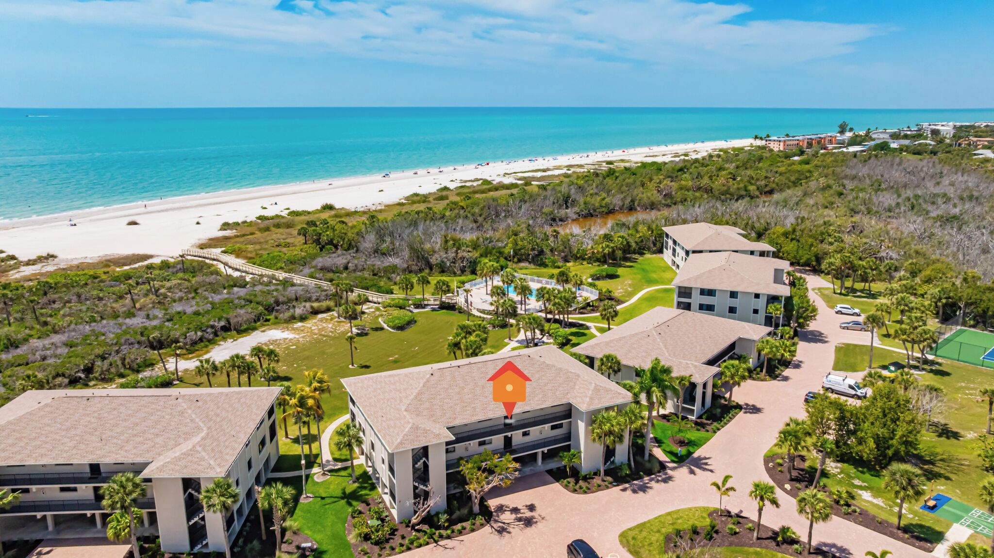 A resort with multiple buildings, a beach, and a golf course.