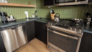 A modern kitchen with a dishwasher, stove, microwave, and green tiled backsplash. - Sosuite | 2BR Apt w W/D, Newly renovated (Philadelphia)