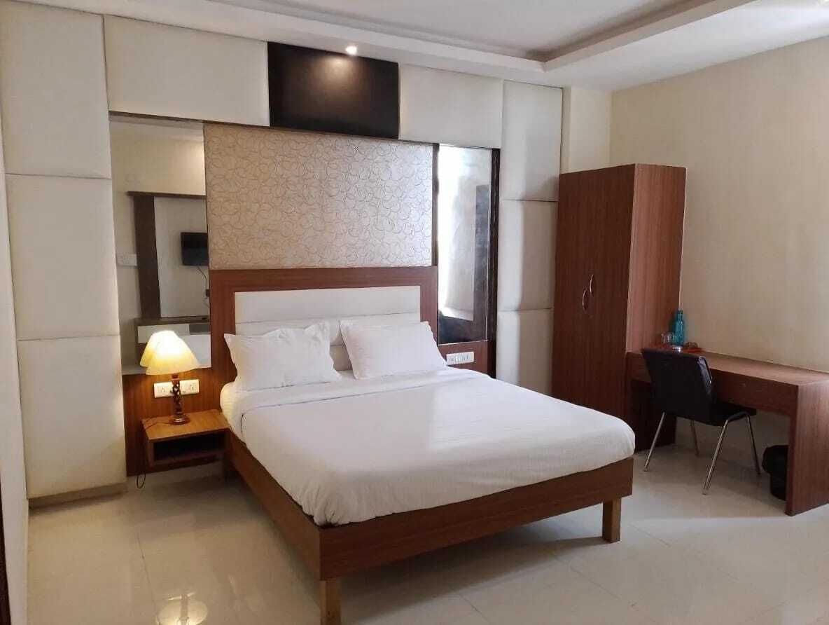 Une chambre d’hôtel avec un grand lit, un bureau et une armoire.
