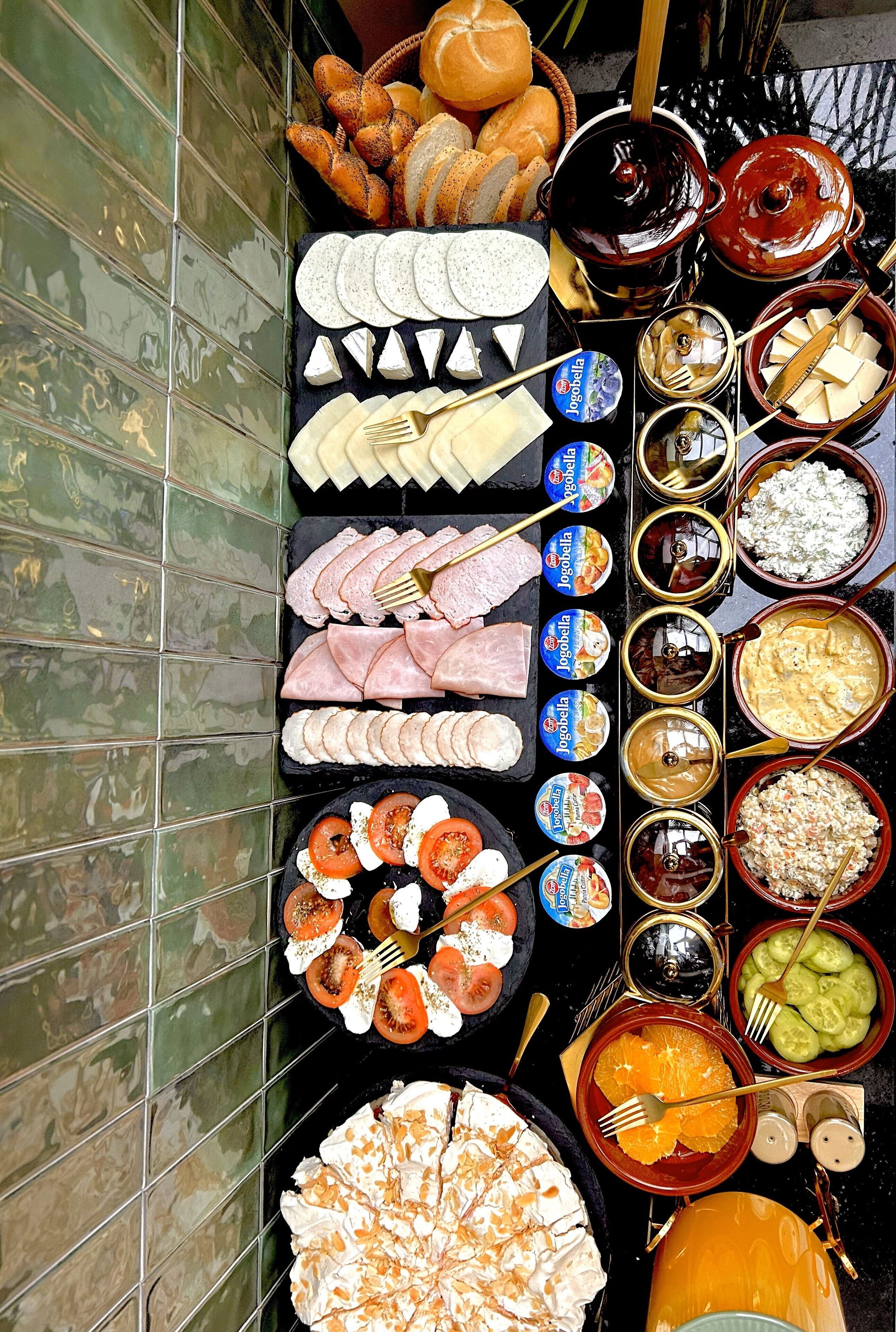 A variety of food items and condiments arranged on a table against a tiled wall.