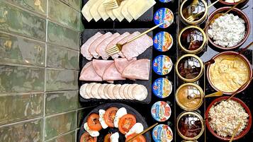 A variety of food items and condiments arranged on a table against a tiled wall.