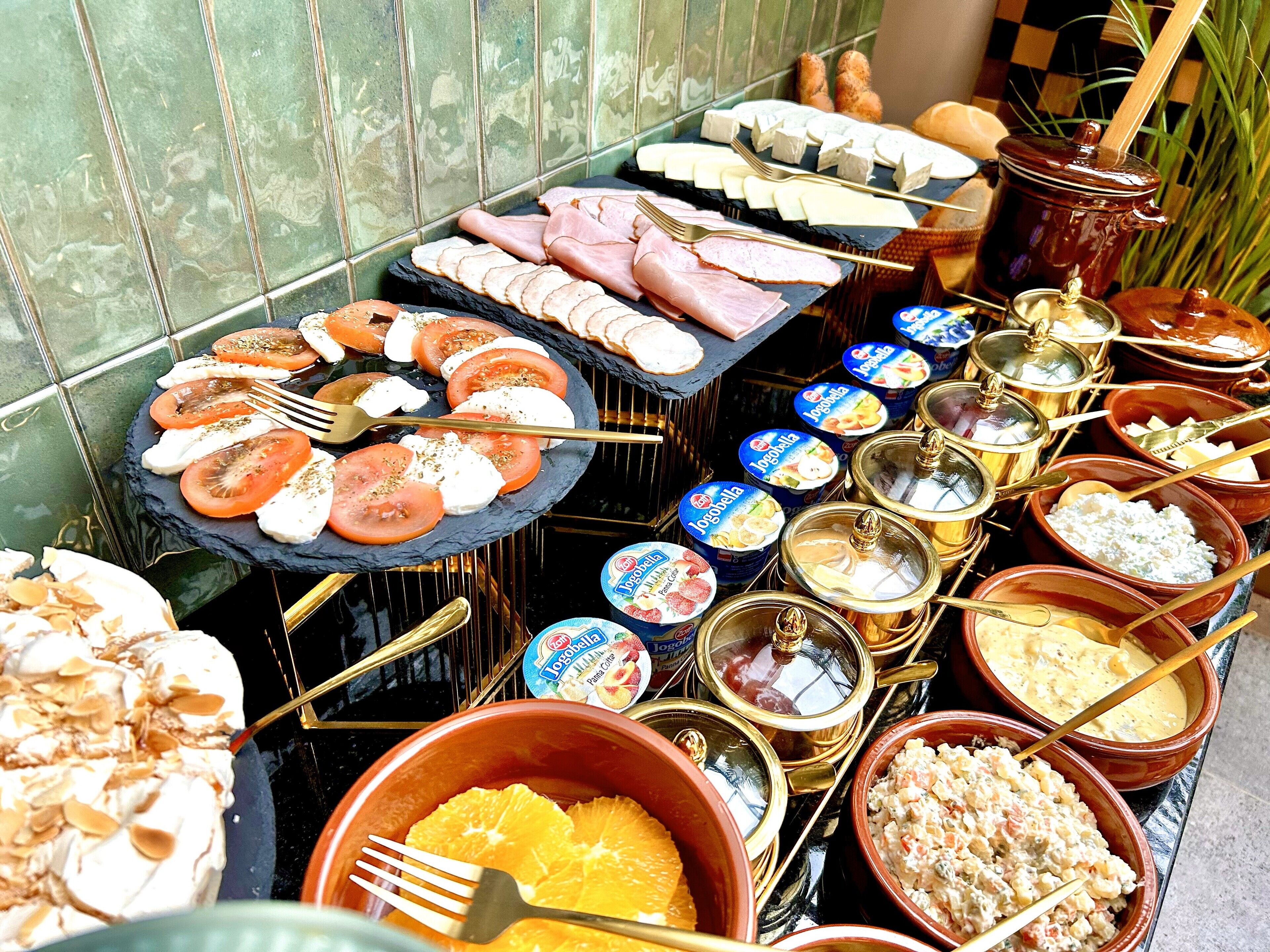 Ein reichhaltiges Buffet mit verschiedenen Speisen, darunter Käse, Fleisch und Obst.