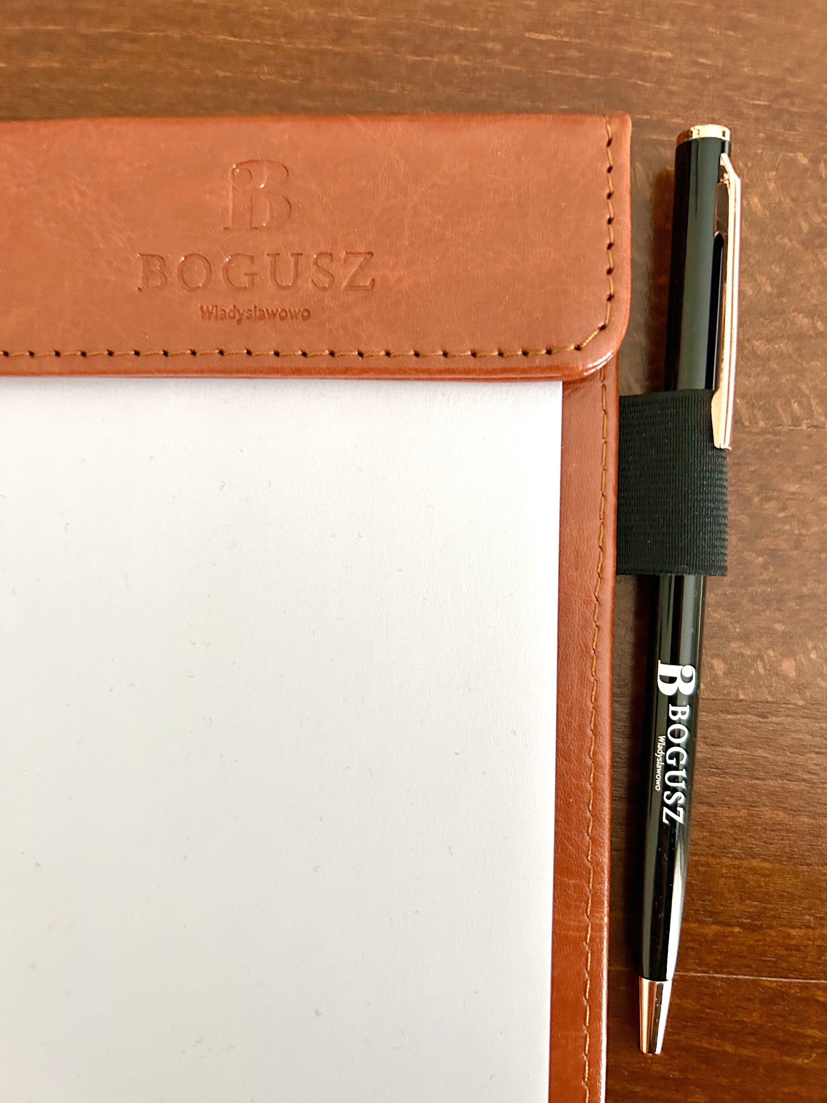 A brown leather notebook with the brand name "BOGUSZ" embossed on the cover.