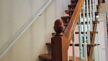Een houten trap met witte spijlen en een houten leuning.