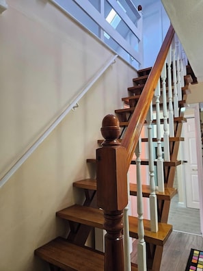 A wooden staircase with white balusters and a wooden handrail.