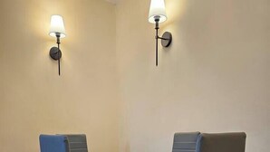 Una sala da pranzo con un tavolo rettangolare, quattro sedie e due lampade a parete.