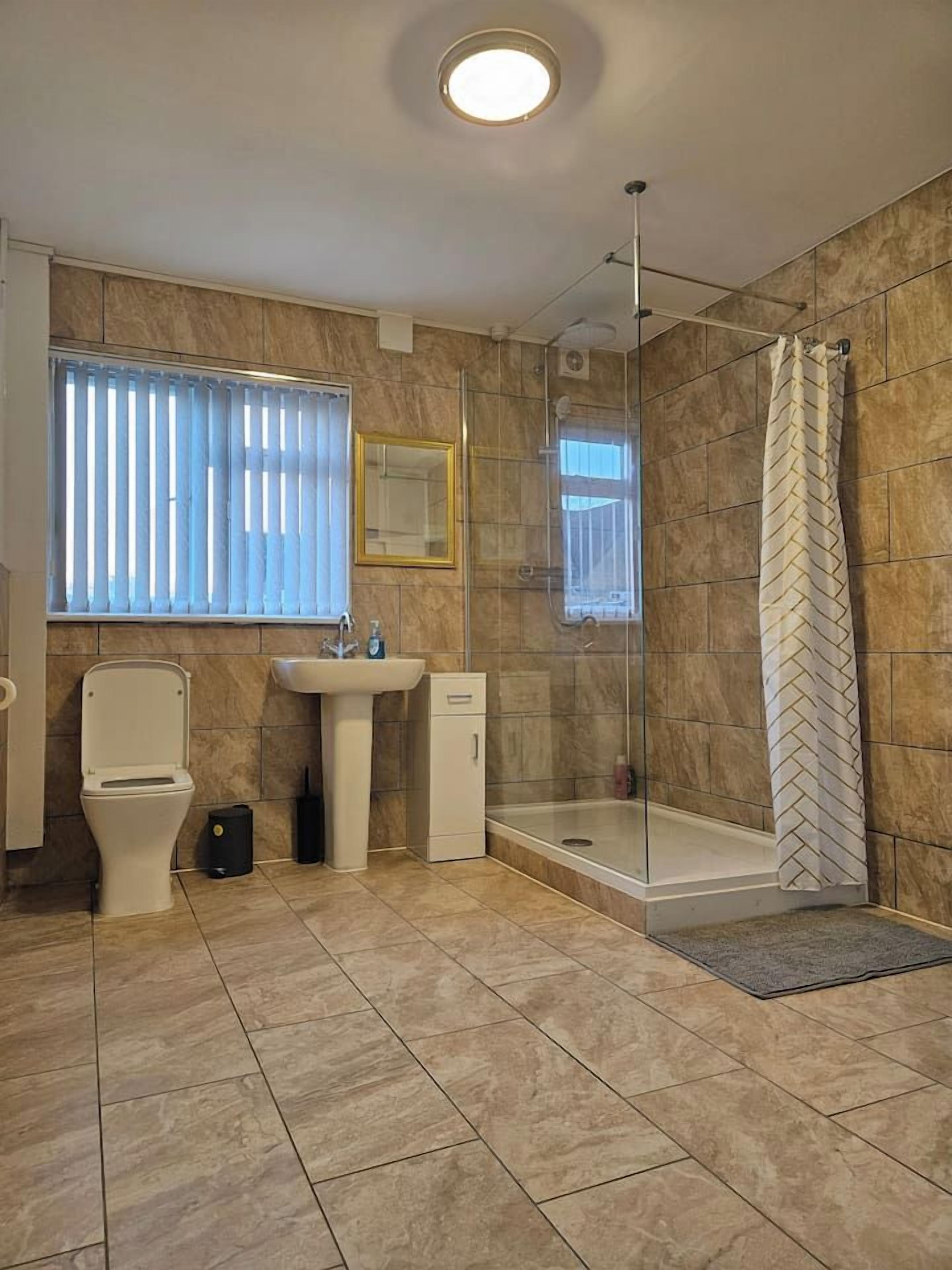 A bathroom with a toilet, sink, and glass-enclosed shower.