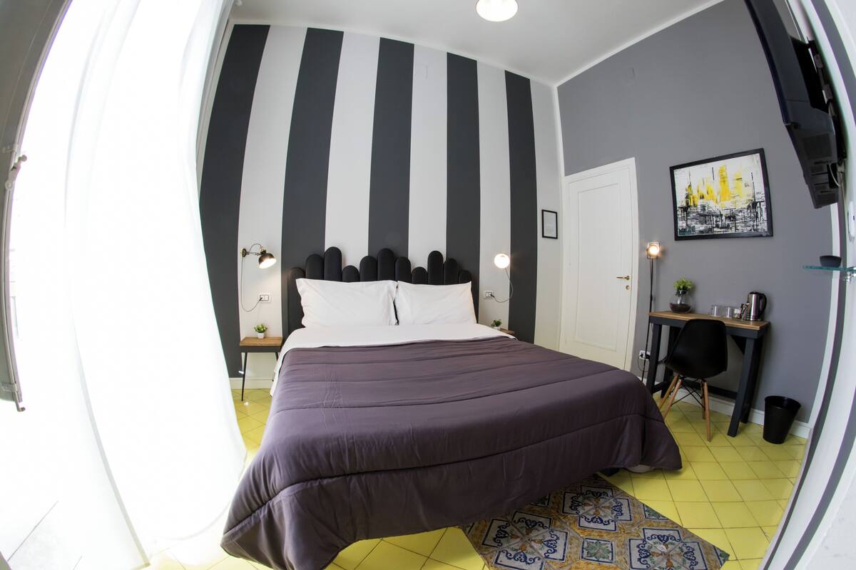 Quarto com cama, escrivaninha e cadeira.