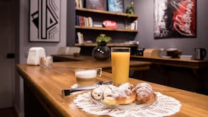 A breakfast table with croissants, a glass of orange juice, and a coffee cup. - Balate maqueda bnb (Palermo)