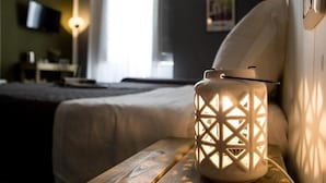 A white, intricately designed lantern on a wooden nightstand in a hotel room. - Balate maqueda bnb (Palermo)