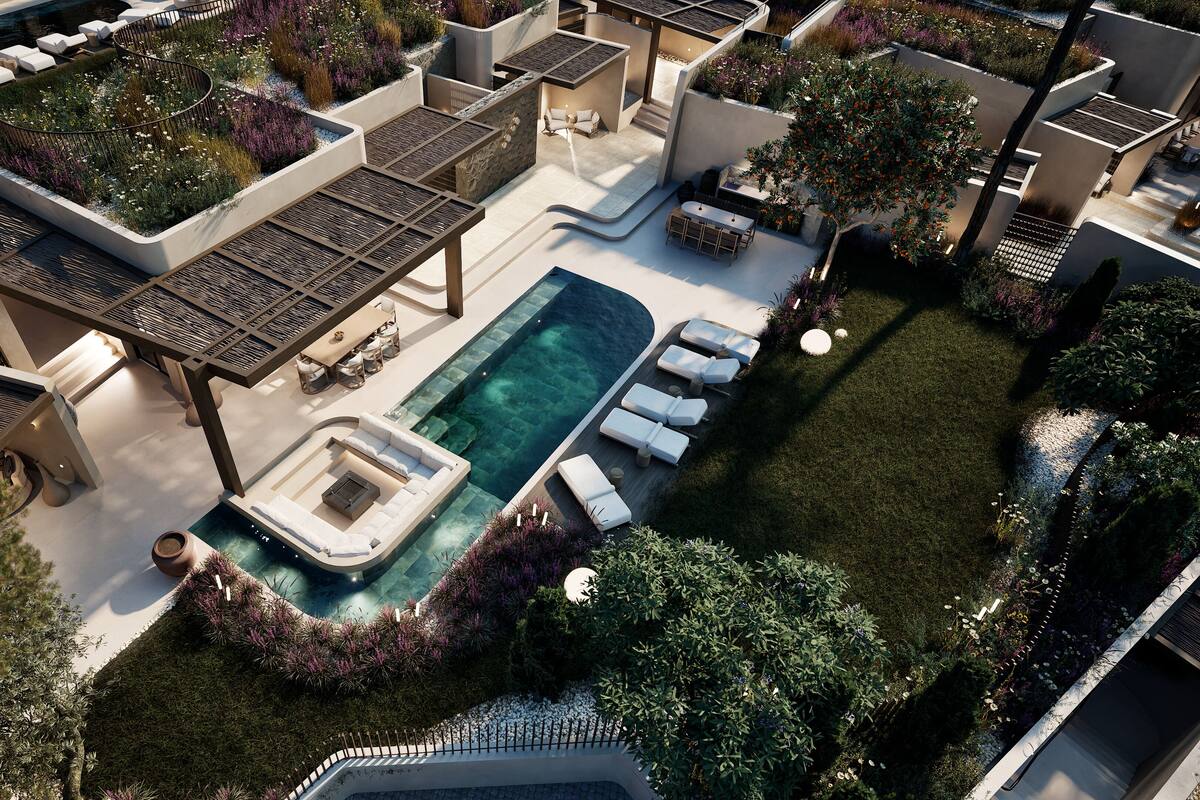 An aerial view of a modern outdoor pool area with lounge chairs, a hot tub, and a well-maintained garden.