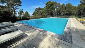 A rectangular swimming pool with a clear blue water surface, surrounded by a tiled deck and lounge chairs. - Gîte Lavande with swimming pool in the heart of Provence with a sensational view! (Saumane-de-Vaucluse)
