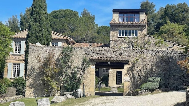 A stone building with a modern upper section and a traditional lower section, surrounded by trees and a gravel path. - Gîte Lavande with swimming pool in the heart of Provence with a sensational view! (Saumane-de-Vaucluse)