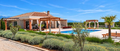 Uma casa com piscina, área de estar externa e jardim.