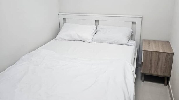 A small, neatly made bed with white bedding in a minimalistic room. - 3 Min Walk To Dubai Mall Lux Hostel (Dubai)