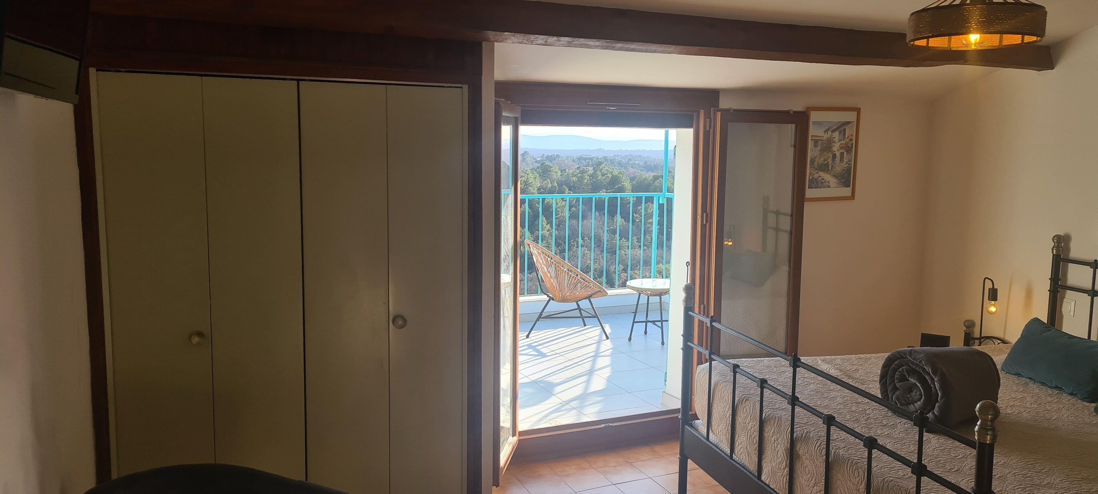 Une chambre à coucher avec un lit, un balcon et une vue sur l’extérieur.