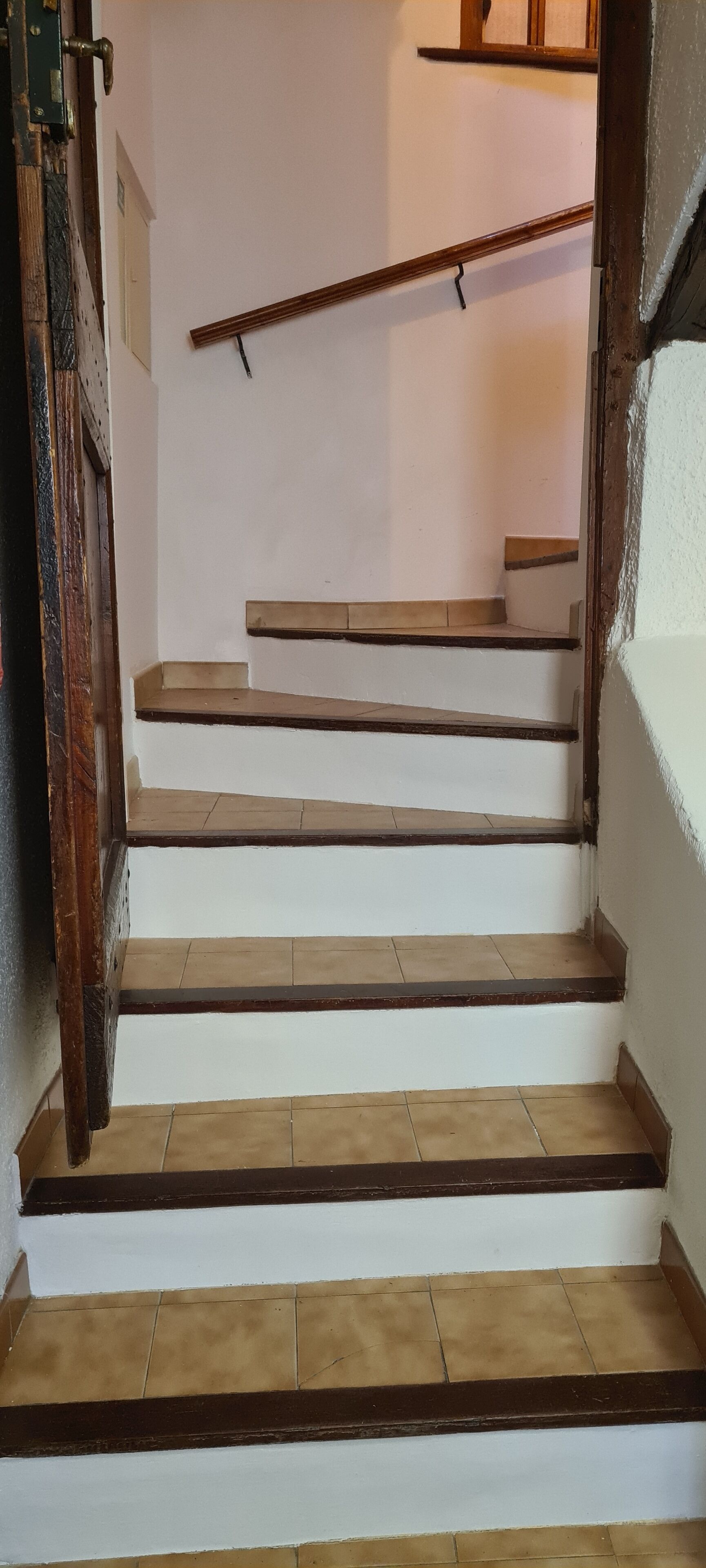 Un escalier avec des murs blancs et des marches en bois.