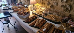 Ein reichhaltiges Frühstücksbuffet mit verschiedenen Brotsorten, Gebäck und Aufstrichen.