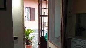 A laundry room with a washing machine, a drying rack, and a potted plant. - Cozy studio apartment with loft in San Lorenzo (Roma)