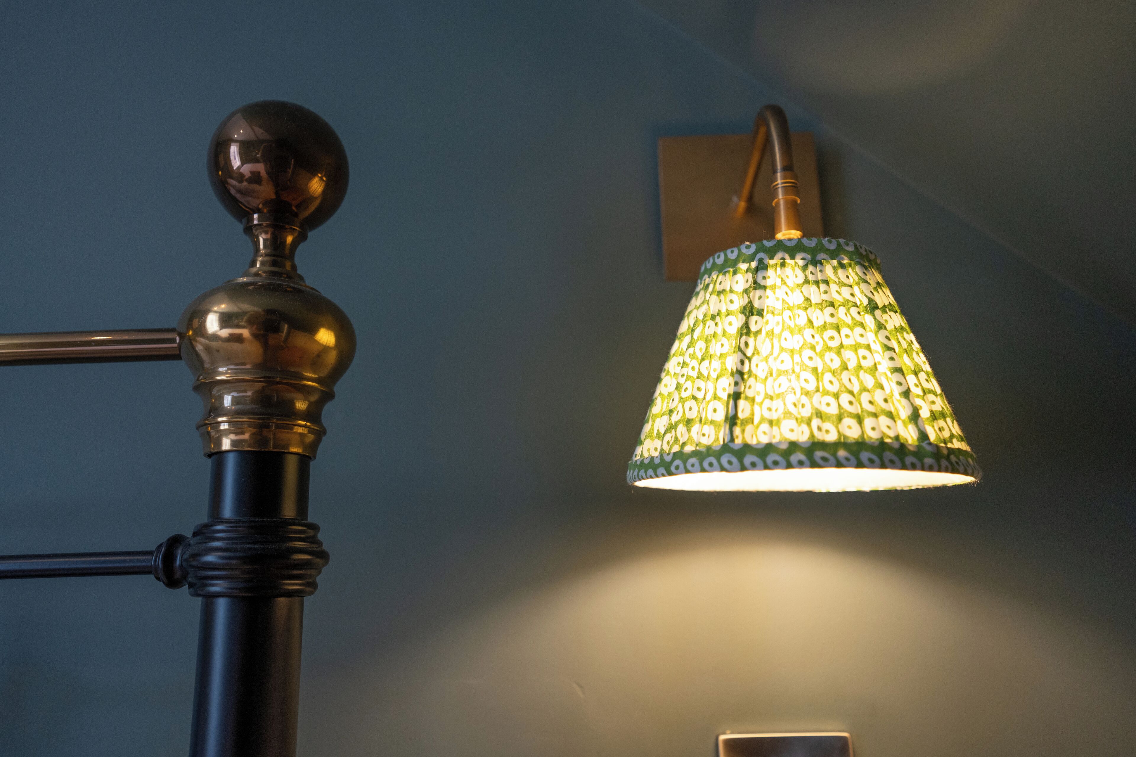 Une lampe avec un abat-jour à motifs et un pied en métal.