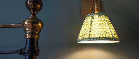 Une lampe avec un abat-jour à motifs et un pied en métal.