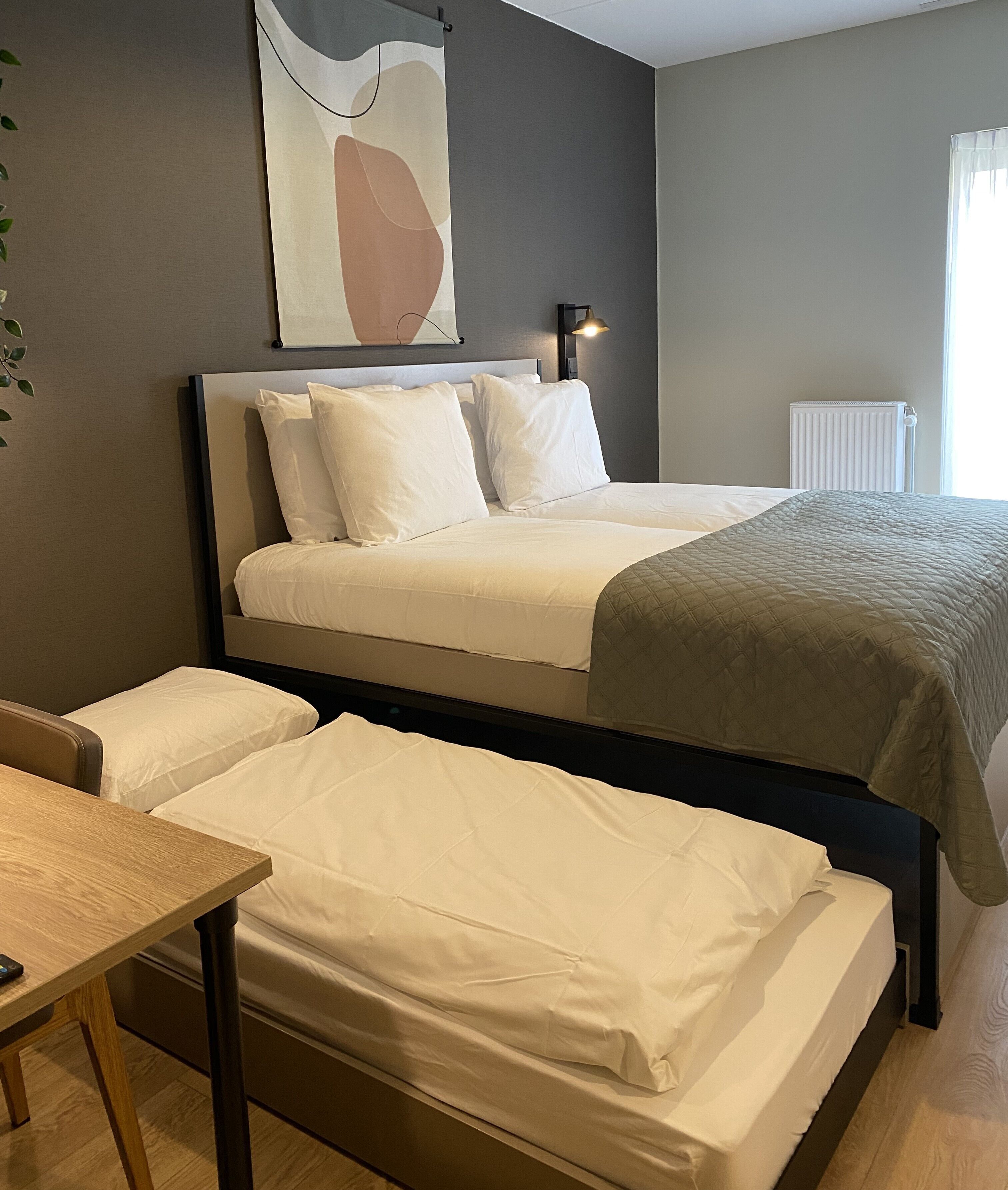 A bedroom with a bed, a bedside table, and a radiator.