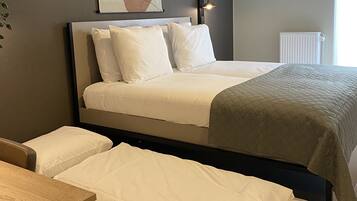 A bedroom with a bed, a bedside table, and a radiator.