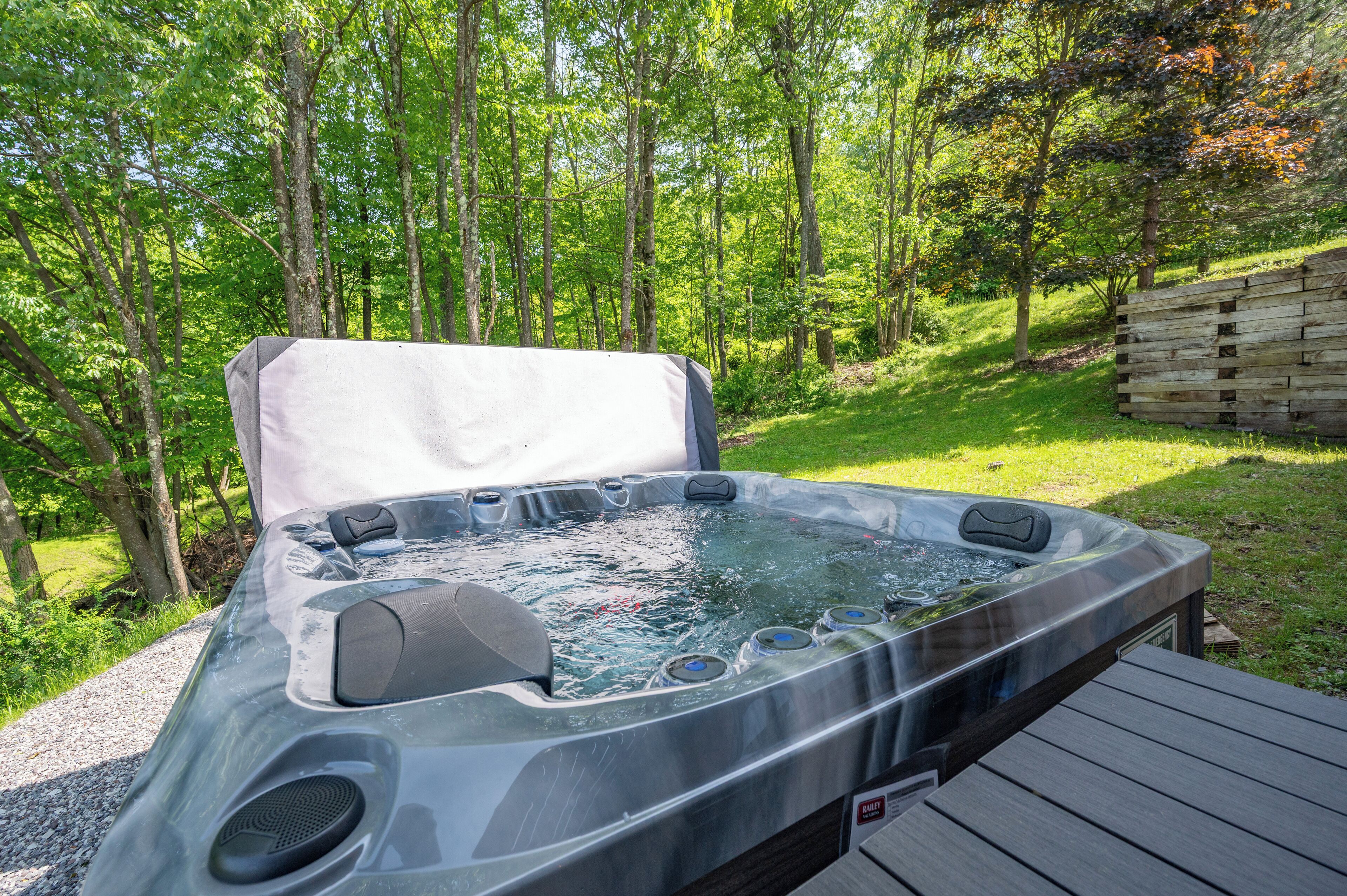 A hot tub in a wooded area with a wooden deck.