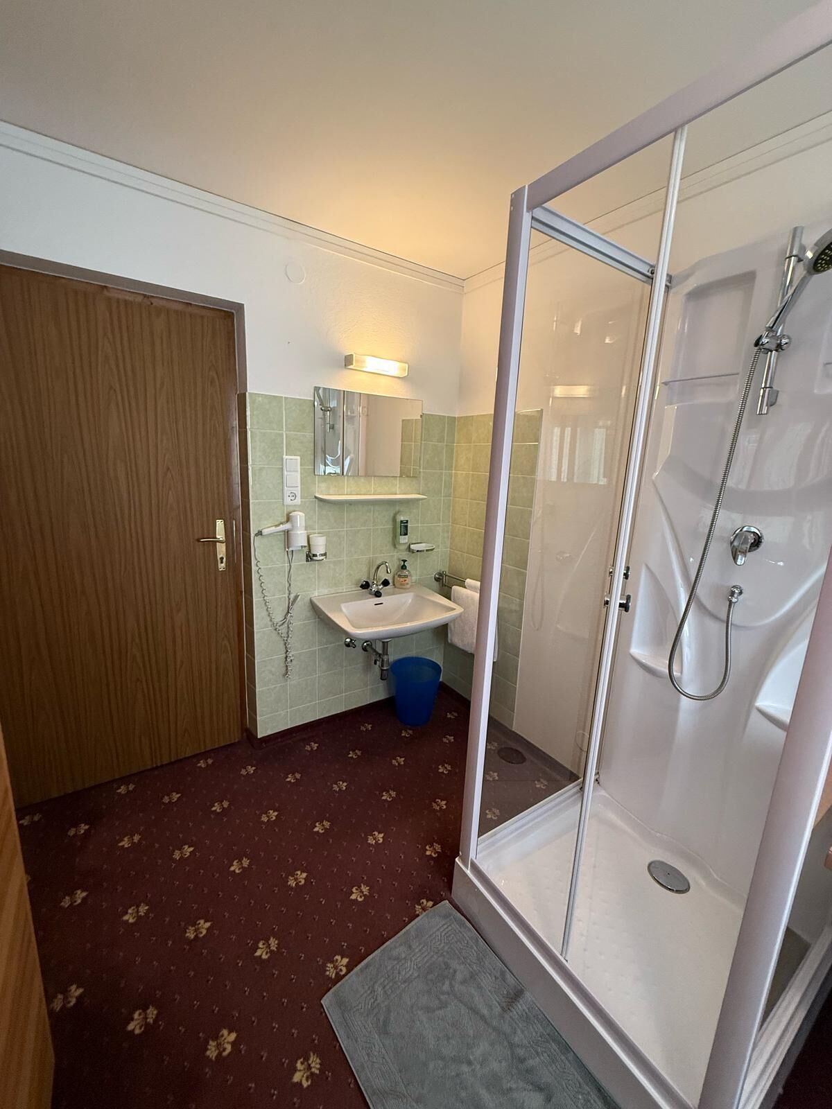 Une salle de bain avec une douche, un lavabo et un miroir.