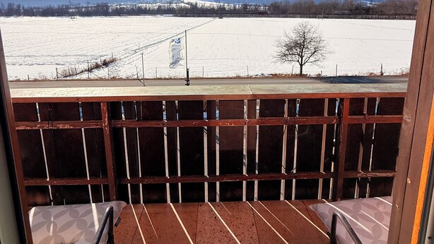A balcony with a view of a snow-covered landscape and mountains. - Pension Plattenhof  (Telfs)