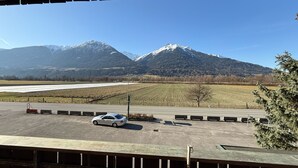 A parking area with a car, a snow-capped mountain, and a clear sky. - Pension Plattenhof  (Telfs)