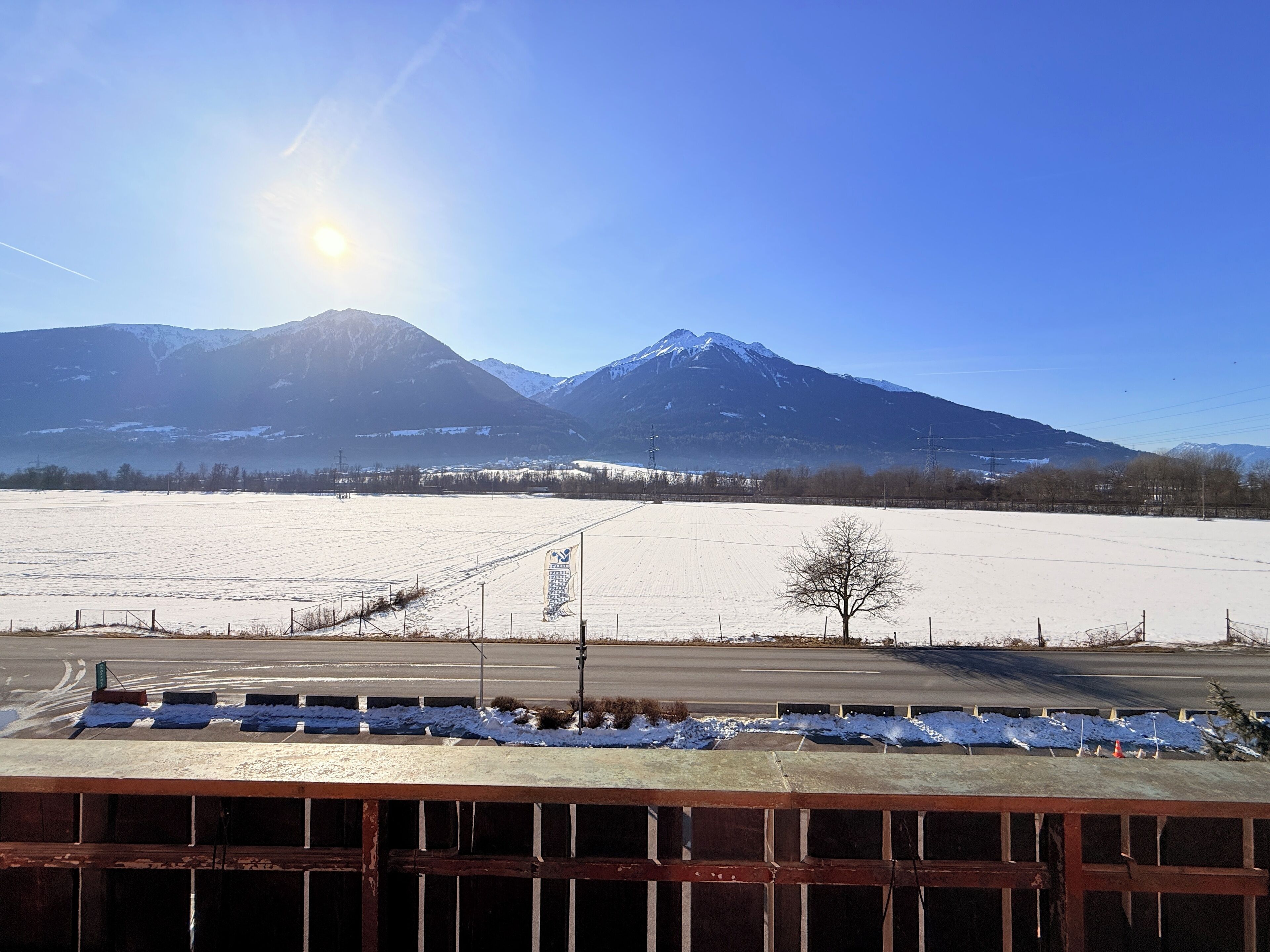 A snowy landscape with a mountain in the background and a clear sky.