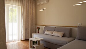 Una sala de estar moderna con un sofá, una mesita auxiliar y una ventana con cortinas.