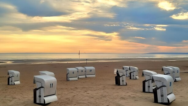 Portable RV-style units numbered 11, 6, 19, 27, and 70 on a beach with a sunset in the background. - Studio SABLE & MER (Merville-Franceville-Plage)