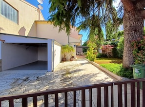 A residential area with a paved driveway, potted plants, and a tree. - Sunny Street Holiday Home (Rovinj)