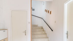 Un escalier avec une main courante noire menant à un palier.