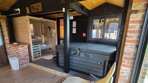 Ein gemütliches Zimmer mit einem Bett, einem kleinen Tisch und einem Stuhl. Ein Fenster und eine Tür sind vorhanden.