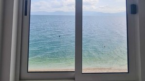 Una habitación con un gran ventanal con vistas a una playa y al mar.